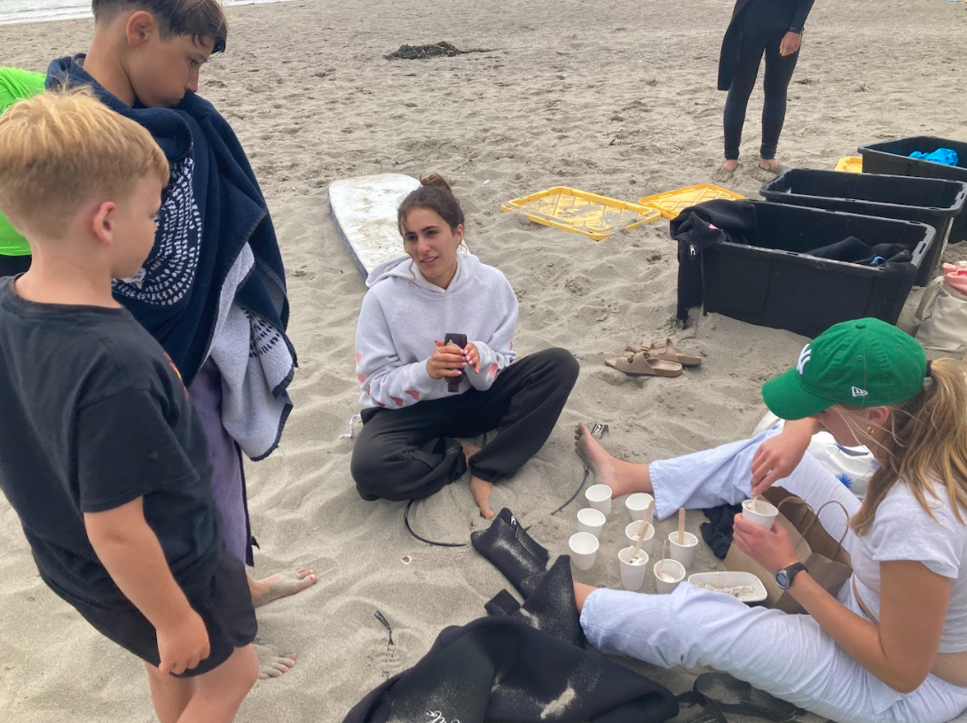 SurfWorks counselors, seated from left, Maya and Charlotte prepare ice cream sundaes for campers on the last day June 21, 2024, at Stinson Beach. 